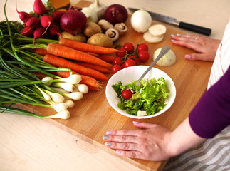 Young woman cutting vegetables in the kitchen