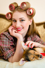 pinup girl with curlers hand on her little puppy 