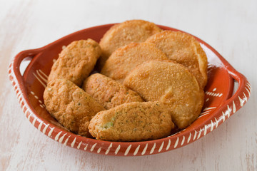 meat and cod fish croquete on dish on white wooden background