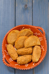 meat and cod fish croquete on dish on blue wooden background
