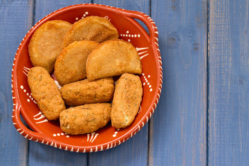 meat and fish croquete on dish on blue wooden background