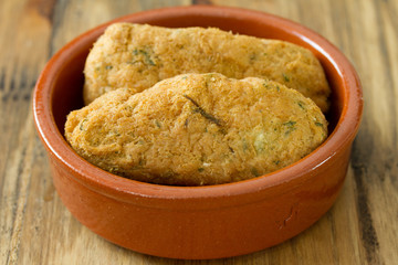 cod fish croquettes on dish on brown background