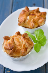 pie with chicken with basil on white plate on blue background