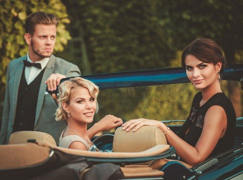 Wealthy friends in a classic convertible