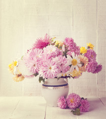 Retro still life with colourful chrysanthemums bunch on old  wooden board. Toned image