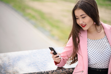 Smiling asian woman with phone