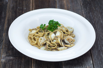 Spaghetti alla vongole on a wooden background