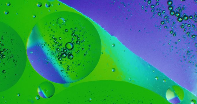 Oil drops floating in water over a colorful underground with oil painting effect. Shot on RED 