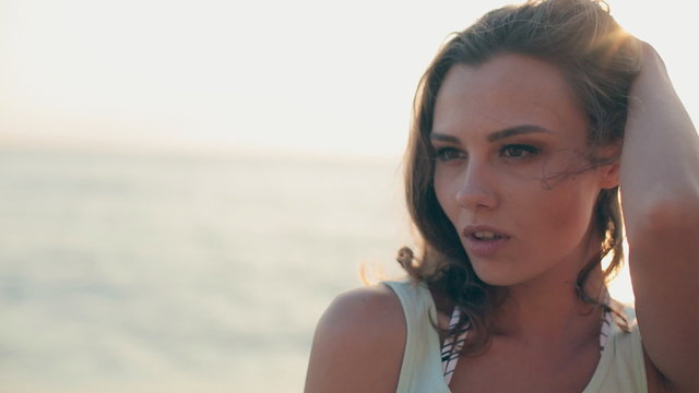 Beautiful girl standing in the sea with a monopod and makes