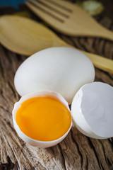Still life broken white eggs and egg yolk on a wooden rustic bac