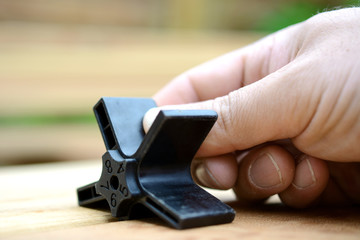 Schreiner oder Handwerker benutzt Distanzhalter für Montage von Holzdiele für Terrasse 