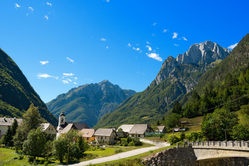 Fototapeta na wymiar Small Village and Julian Alps - Slovenia / Small village (Bretto) in Julian Alps in the Triglav National Park - Bovec, Slovenia, Europe