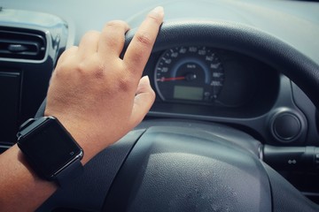 Woman hands drive a car with smartwatch