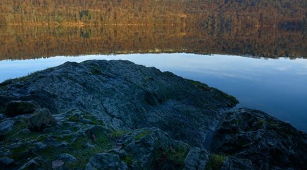 Rocher devant un lac à l'automne