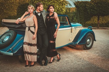 Wealthy friends near classic convertible