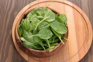 Young spinach in a wooden plate