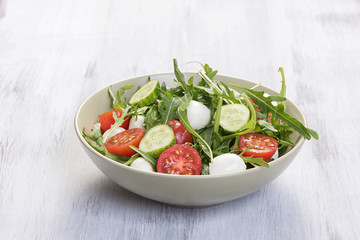 Green salad made with arugula, tomatoes, mozzarella