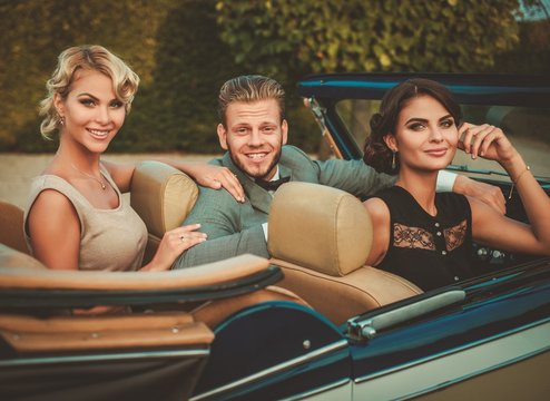 Wealthy friends in a classic convertible