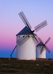 Fototapeta na wymiar Two windmills at field in evening