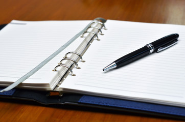 Hand with a pen writing on white paper (Business, Education) - Selective focus