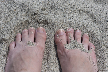 woman feet on the sand of the beach under danger of disease