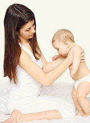 Mom and baby together on the bed at home