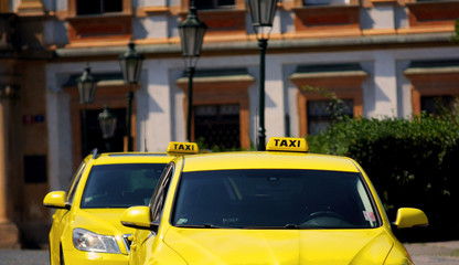 Two yellow taxi cars with taxi signs on the roof. Stock photo.