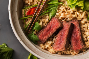 A bowl of Chinese ramen noodles with beef, Chinese cabbage, chil