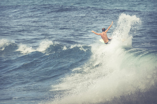 Vintage photo professional surfer rides a giant wave.