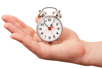 Close-up image of human palm with alarm clock isolated on a white background