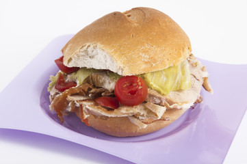 porchetta sandwich with lettuce and tomatoes