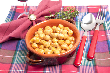 Burlap sack with chickpeas spilling out over a white background