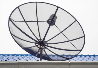 Black satellite dish on the blue roof, On the day of an overcast sky background.