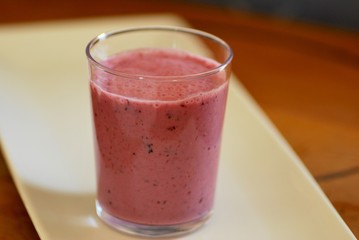 pink smoothie with berries and yoghurt on white tray