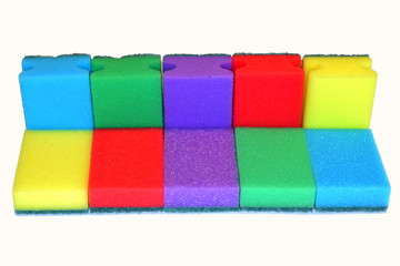 Яркие разноцветные губки для уборки и мойки посуды на белом фоне