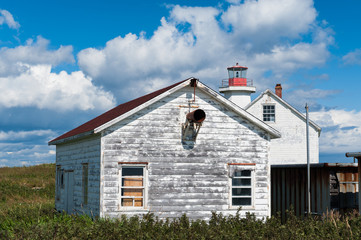 Fototapeta na wymiar old-fashioned rustic house and lighthouse, Mingan, Quebec, Canada