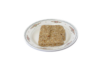 Peanut bar at the dish on white background.
