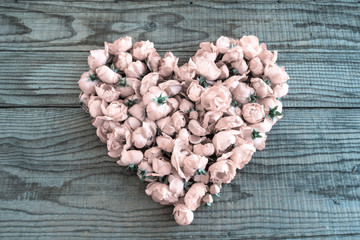 Heart made of red roses in wooden background to represent personal feelings, vintage effect