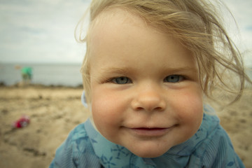little girl laughing on the beach .