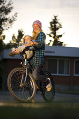 Naklejka premium girl playing the mother climbed on a bicycle