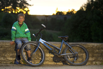 Obraz premium young boy with a bicycle in nature rests.