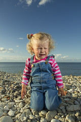 little girl weeping by the sea.