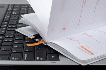 computer with notebook and a pen