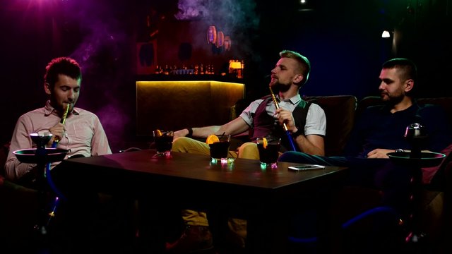 Boys smoking hookah in the lounge caffee