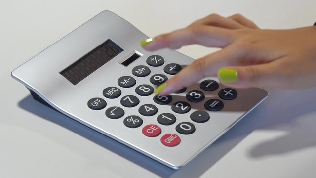 a woman makes accounts with a calculator
