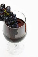 Red wine glass with grape within isolated on white background