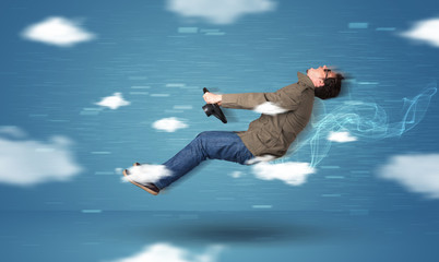 Funny racedriver young man driving between clouds concept