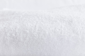 Blurred white towel, blurry textured background.
