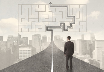 Businessman looking at road with maze and solution
