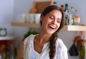 Young woman standing near desk in the kitchen